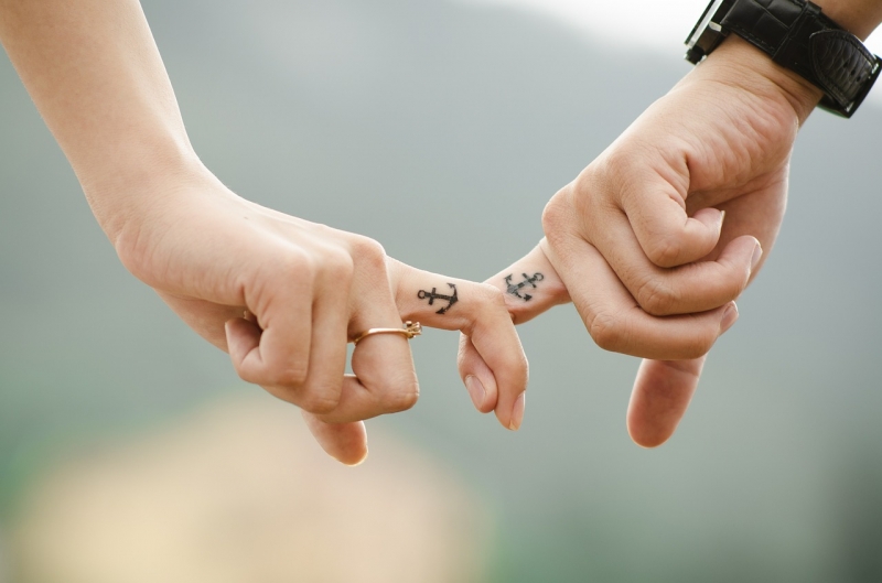 Un couple se tenant les mains avec les doigts